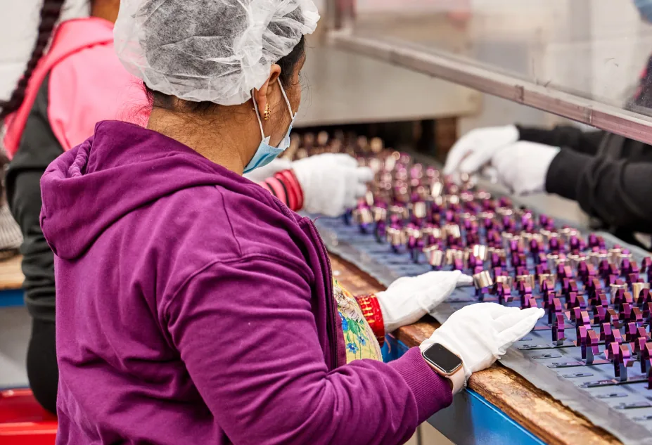 An Anomatic associate inspecting anodized components on the line
