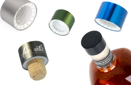 Anodized aluminum screw caps in silver, green and blue, an Anomatic bar-top closure with cork, and a capped whiskey bottle
